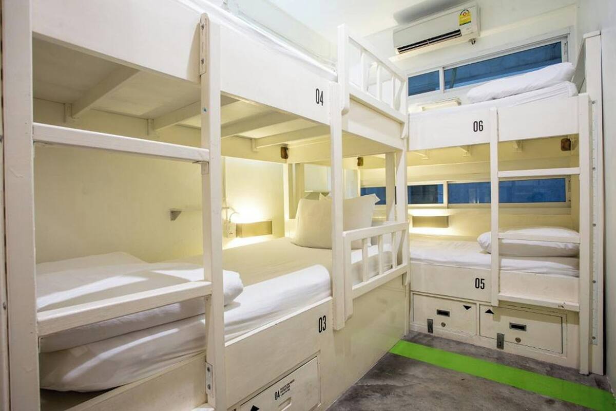 Bunk beds in a room with numbers on the beds, a lamp, and a green floor strip.
