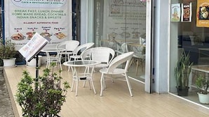 Un restaurant végétarien avec une terrasse et un tableau affichant le menu.