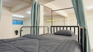 Un lit superposé avec un matelas gris et un seul oreiller.