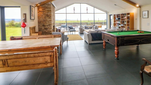 A spacious living area with a pool table, seating, and a view of the outdoors. - Highgate House (Dronfield)