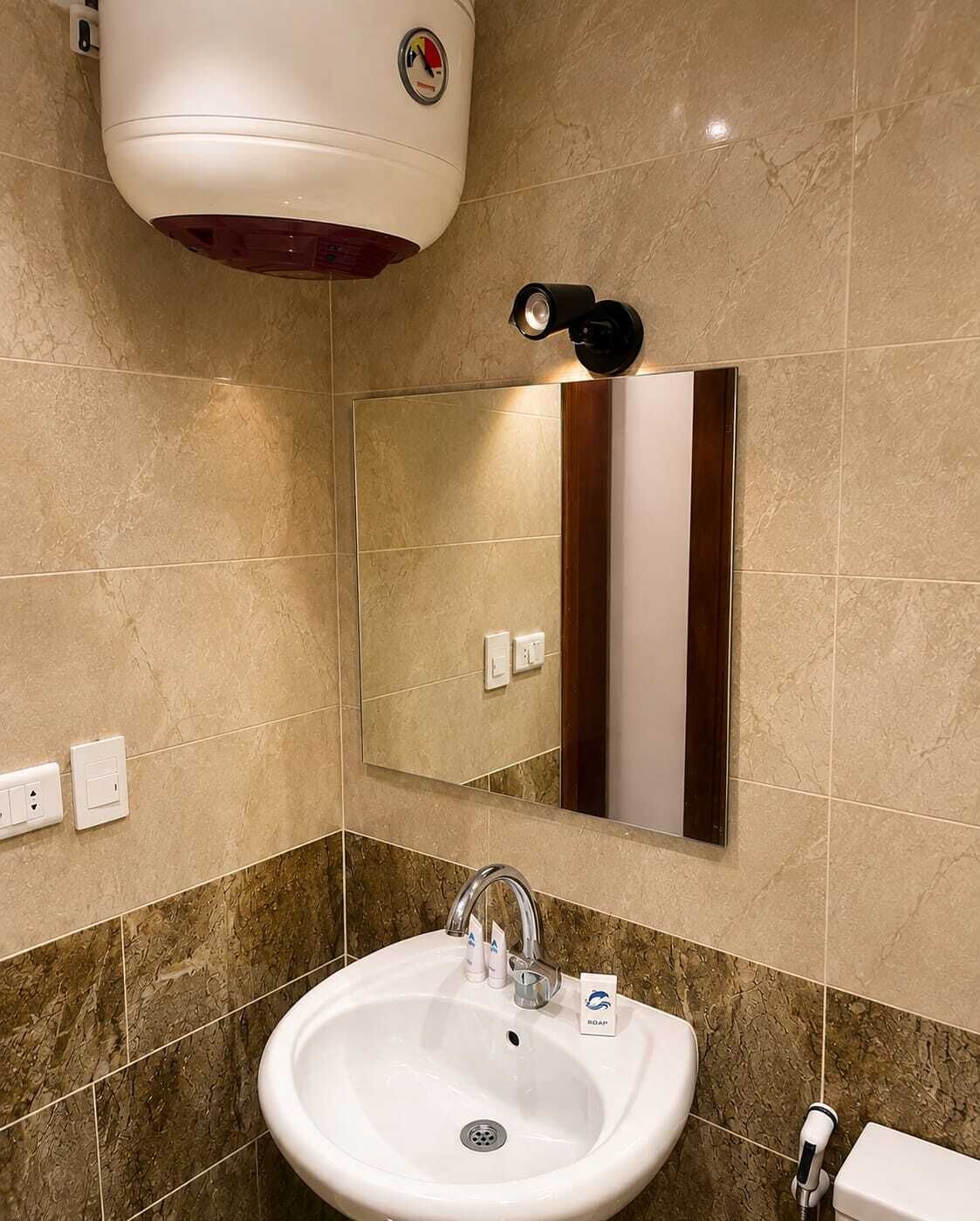 A bathroom with a white sink, a mirror, a hairdryer, and a towel rack.