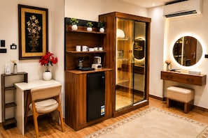 A compact room with a kitchenette, a built-in wardrobe with a mirror, and a small seating area. - Pyramids Kingdom RZ Hotel (Giza)
