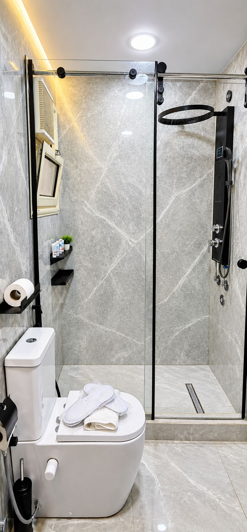A modern bathroom with a glass-enclosed shower, a toilet, and a sink.