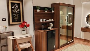 A modern bathroom with a glass shower enclosure, a vanity with a mirror, and a desk with a chair. - Pyramids Kingdom RZ Hotel  (Giza)