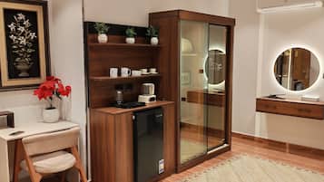 A modern bathroom with a glass shower enclosure, a vanity with a mirror, and a desk with a chair.