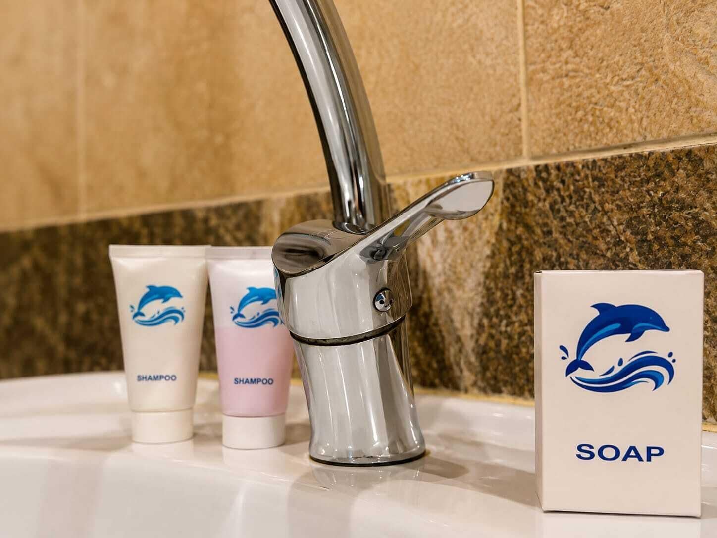 A bathroom sink with a chrome faucet, two shampoo bottles, and a soap box.