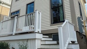 A multi-story building with a white exterior and multiple windows. - Chic 3-bedroom house in Munjoy Hill with off-street parking.   (Portland)
