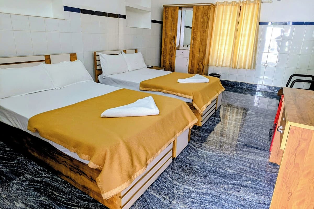 Una camera d'albergo con due letti, un armadio in legno, una scrivania e un bagno con uno specchio e tende.