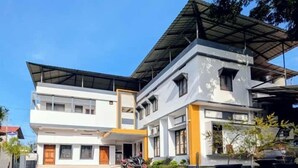 Un edificio moderno a due piani con tetto piano e ingresso coperto.