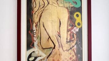 A framed artwork with abstract human figures and geometric shapes.