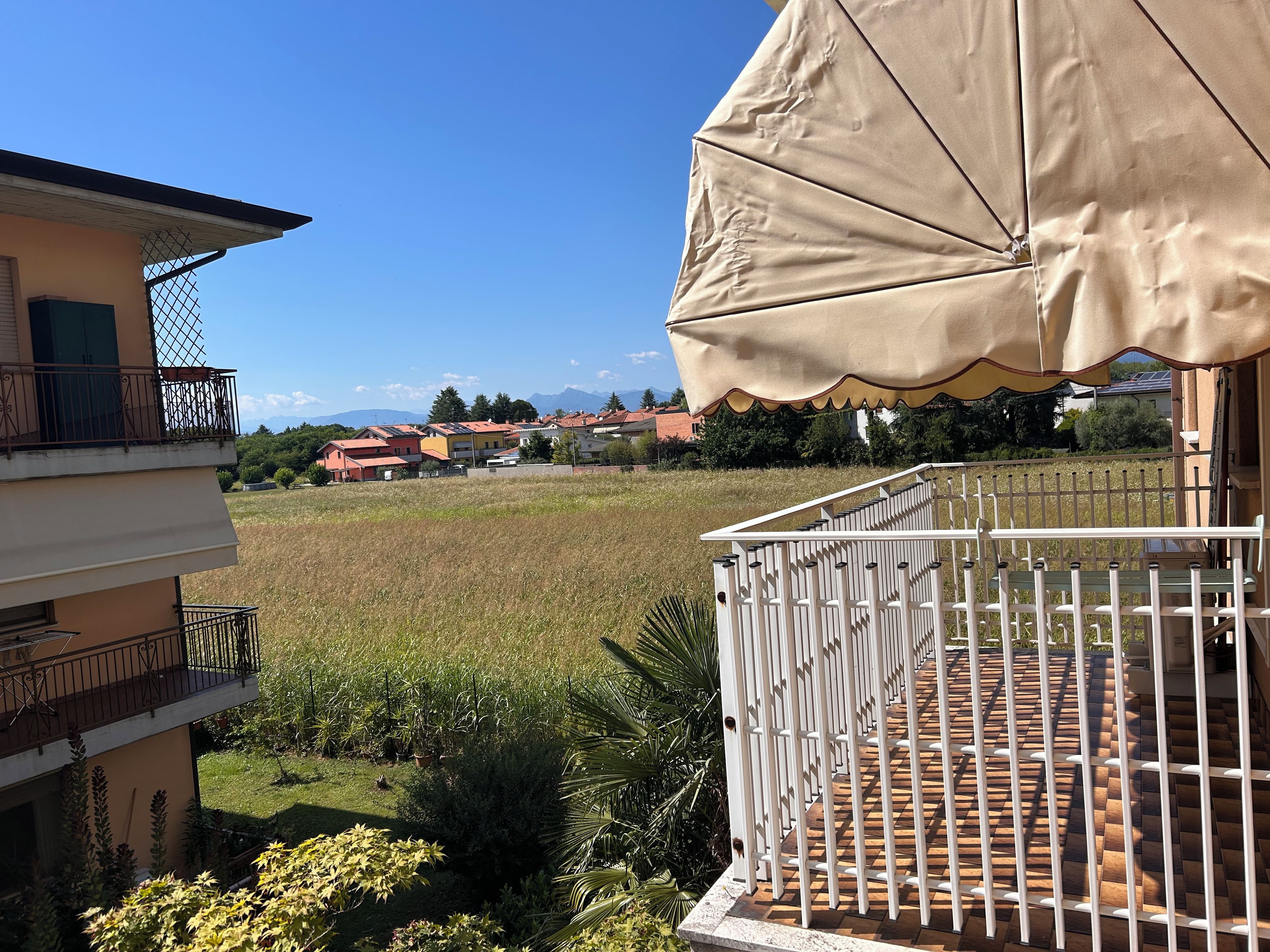 Ein Wohngebiet mit Balkon, Blick auf Häuser und einem Feld.