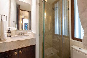 A bathroom with a glass-enclosed shower, a sink, and a toilet. - Luxury Punta Mita Golf Condo – Family Getaway, Private Pools & Beach Clubs (Nayarit)