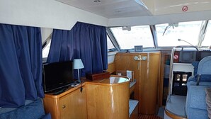 A compact galley with a TV, a small table, and a wooden cabinet.