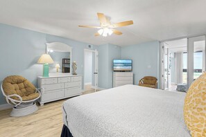 A bedroom with a bed, a dresser, a chair, a ceiling fan, and a TV. - ☀️ Oceanfront with Incredible Amenities-Sunrise 206 ☀️ (New Smyrna Beach)