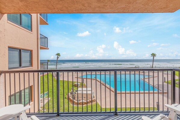 A balcony with a view of a swimming pool and the ocean. - ☀️ Oceanfront with Incredible Amenities-Sunrise 206 ☀️ (New Smyrna Beach)