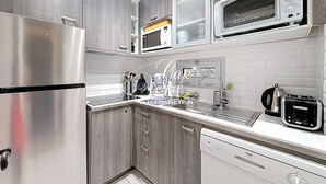 A modern kitchen with stainless steel appliances, a dishwasher, and a microwave. - 3-star-rated cottage for 6 people in a residence with a 50-meter pool near Pramousquier Beach (Le Lavandou)