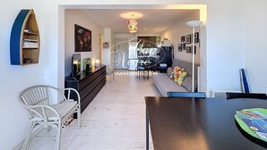 Un salon moderne avec un canapé, une table à manger et une bibliothèque.