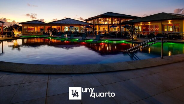 A hotel with a swimming pool, outdoor seating, and a sunset sky. - Baixio Residences by ¼ UmQuarto. (Baixio)