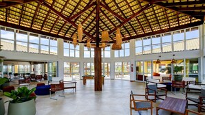 A spacious indoor area with high ceilings, large windows, and a central column. - Baixio Residences by ¼ UmQuarto. (Baixio)