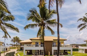 Een resort met meerlaags gebouwen, palmbomen en een heldere lucht.
