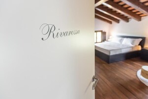 Un dormitorio con una cama, una mesita de noche y un estante en la pared.