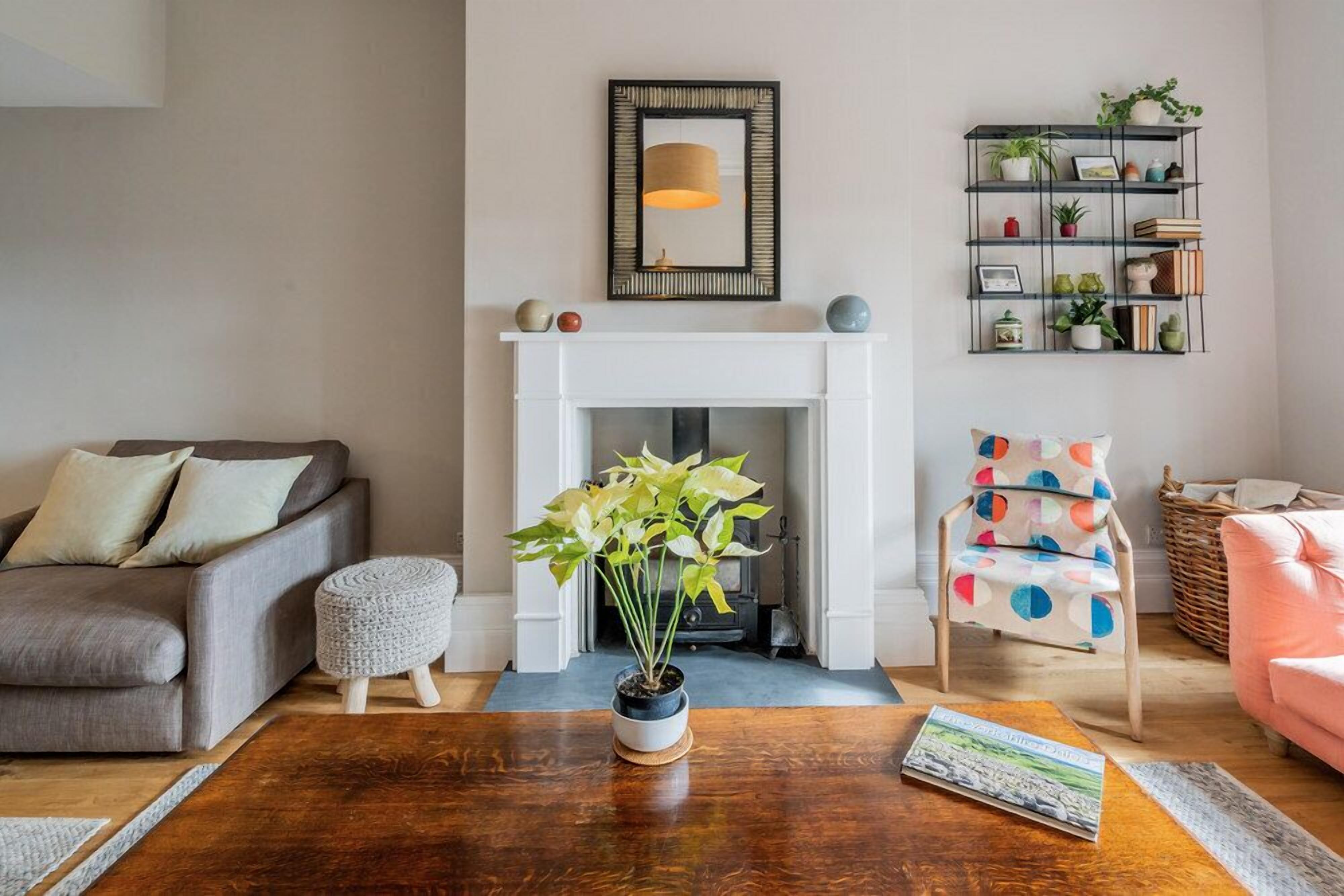 A living room with a fireplace, a sofa, a coffee table, and a chair.