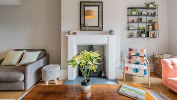 A living room with a fireplace, a sofa, a coffee table, and a chair.