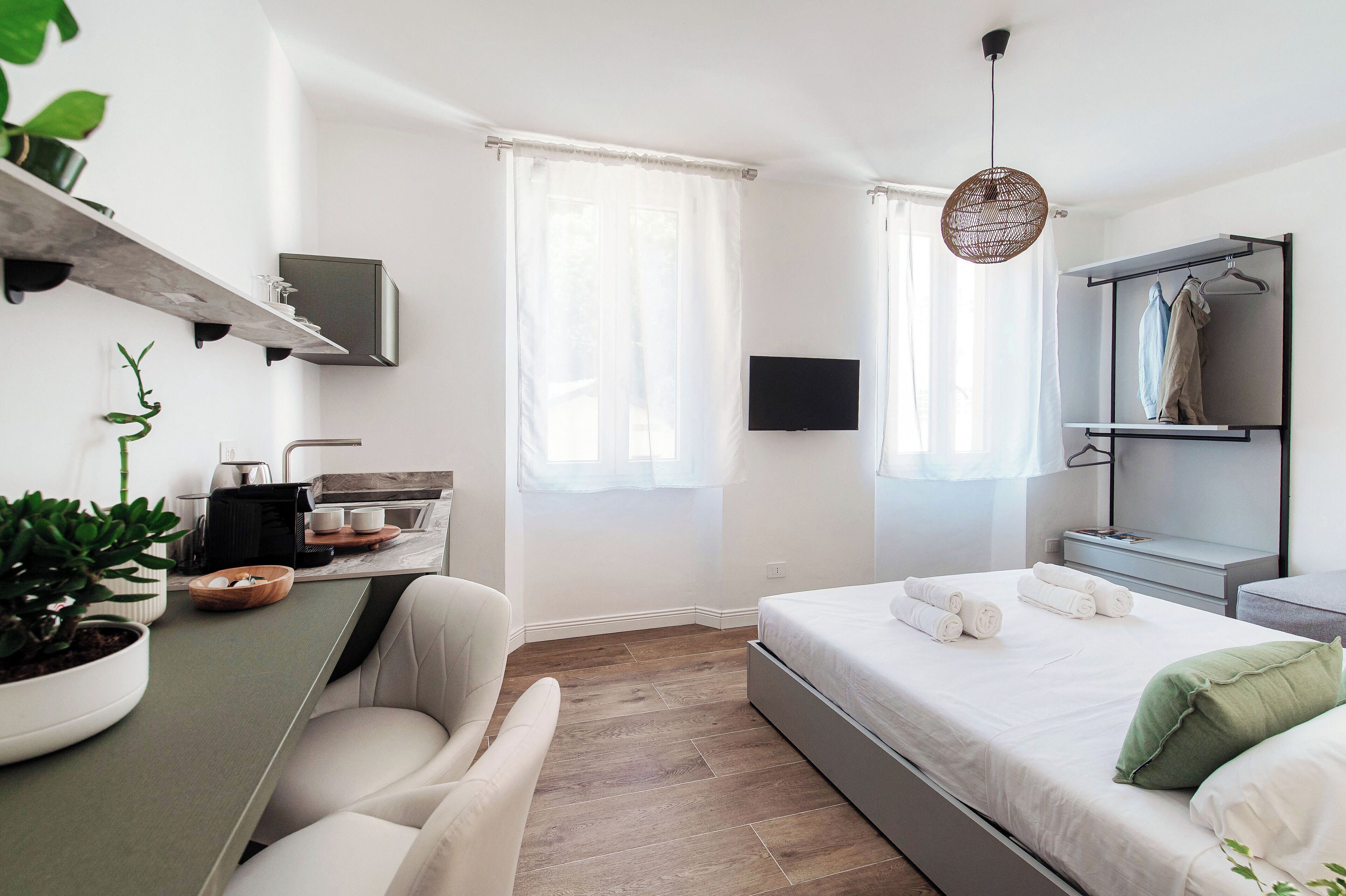 Ein modernes Schlafzimmer mit einem Bett, einem Nachttisch und einem an der Wand montierten Fernseher.