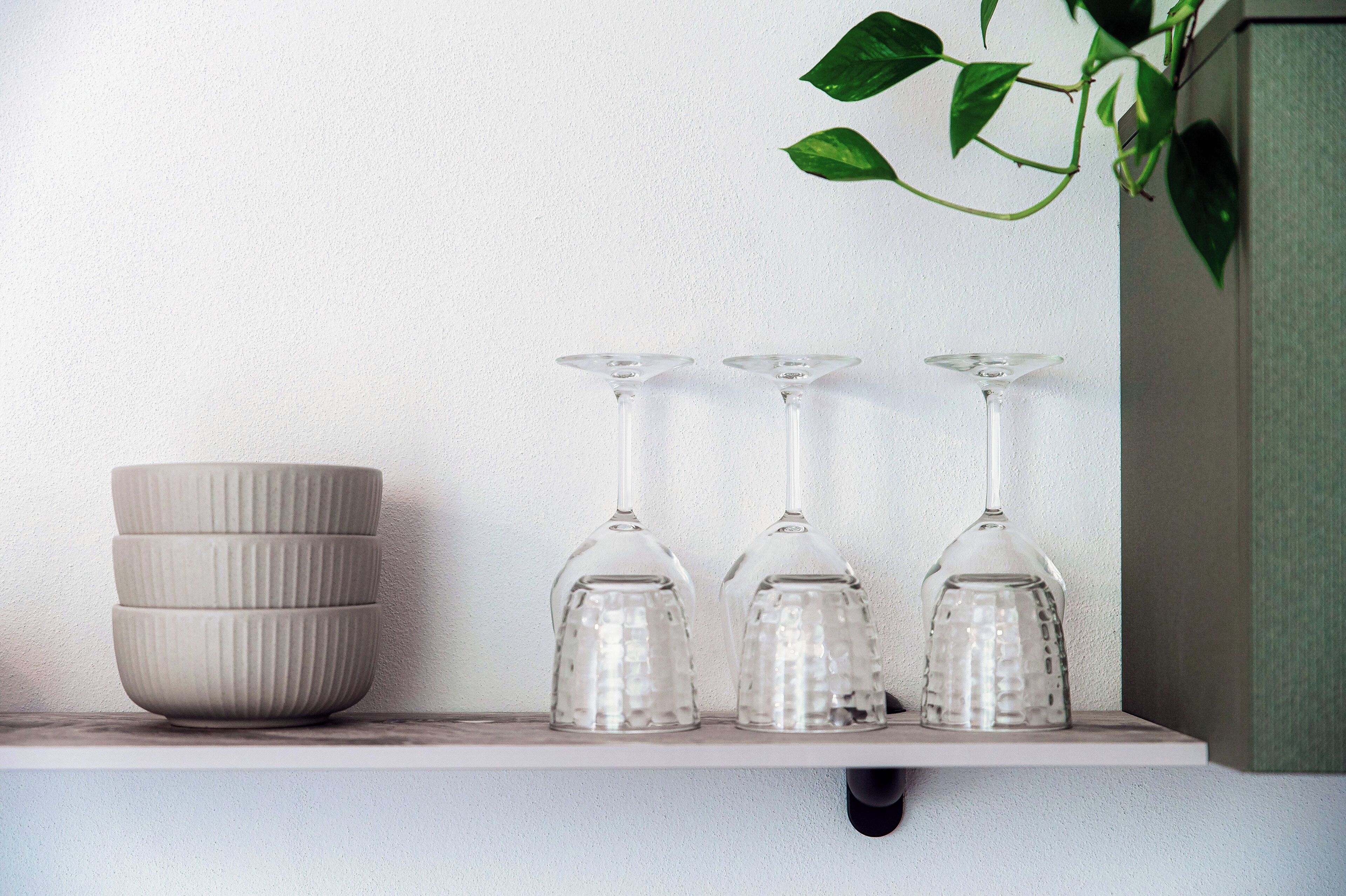 A shelf with three glass tumblers and a textured bowl.