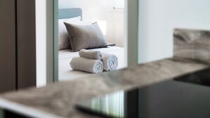 A modern hotel room with a bed, pillows, and rolled towels. - Casa Batèl Suites & Apartments (Como)