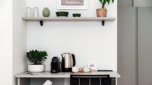 A modern kitchenette with a coffee maker, kettle, and a WiFi sign. - Casa Batèl Suites & Apartments (Como)