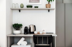 Cocina moderna con encimera blanca, cafetera, hervidor y señal de WiFi.