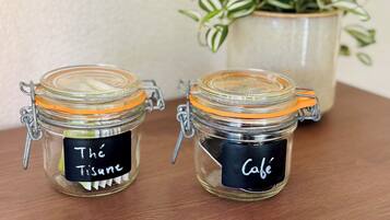 Two glass jars with metal clasps and black labels on a wooden surface.