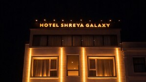 Ein Hotel mit einer gut sichtbaren Schilder, auf denen 'HOTEL SHREYA GALAXY' steht.