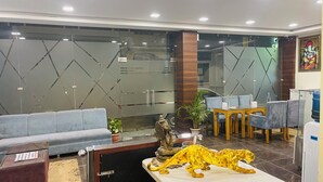 Un espace d’accueil comprenant un canapé, une table, une statue et un distributeur d’eau.