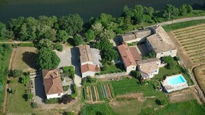 An aerial view of a rural property with multiple buildings, a swimming pool, and a river. - Spacious, bright gîte, ideal for large families or groups of friends. (Ruoms)
