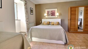 A bedroom with a bed, a nightstand, a window with curtains, and a wooden wardrobe. - Spacious, bright gîte, ideal for large families or groups of friends. (Ruoms)