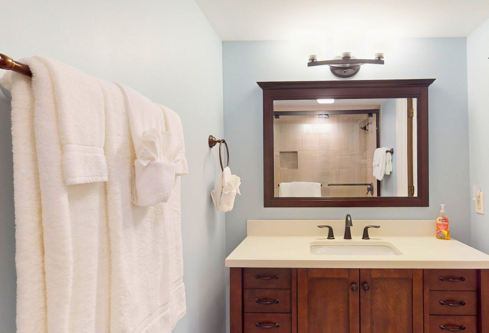 Une salle de bain équipée d’un lavabo, d’un miroir et d’un porte-serviettes.