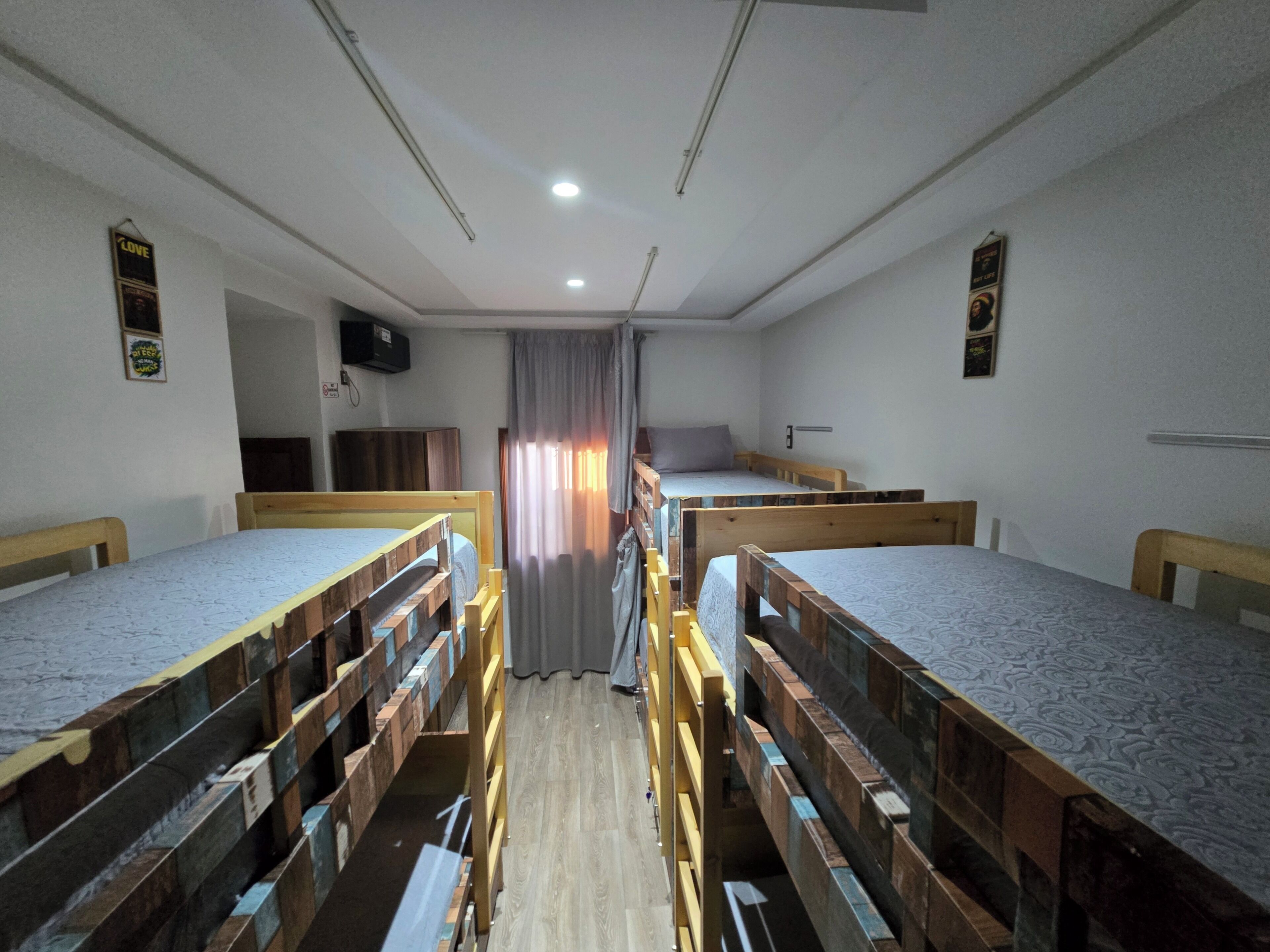 Une chambre de dortoir équipée de lits superposés, d’un bureau, d’une chaise et d’un téléviseur.