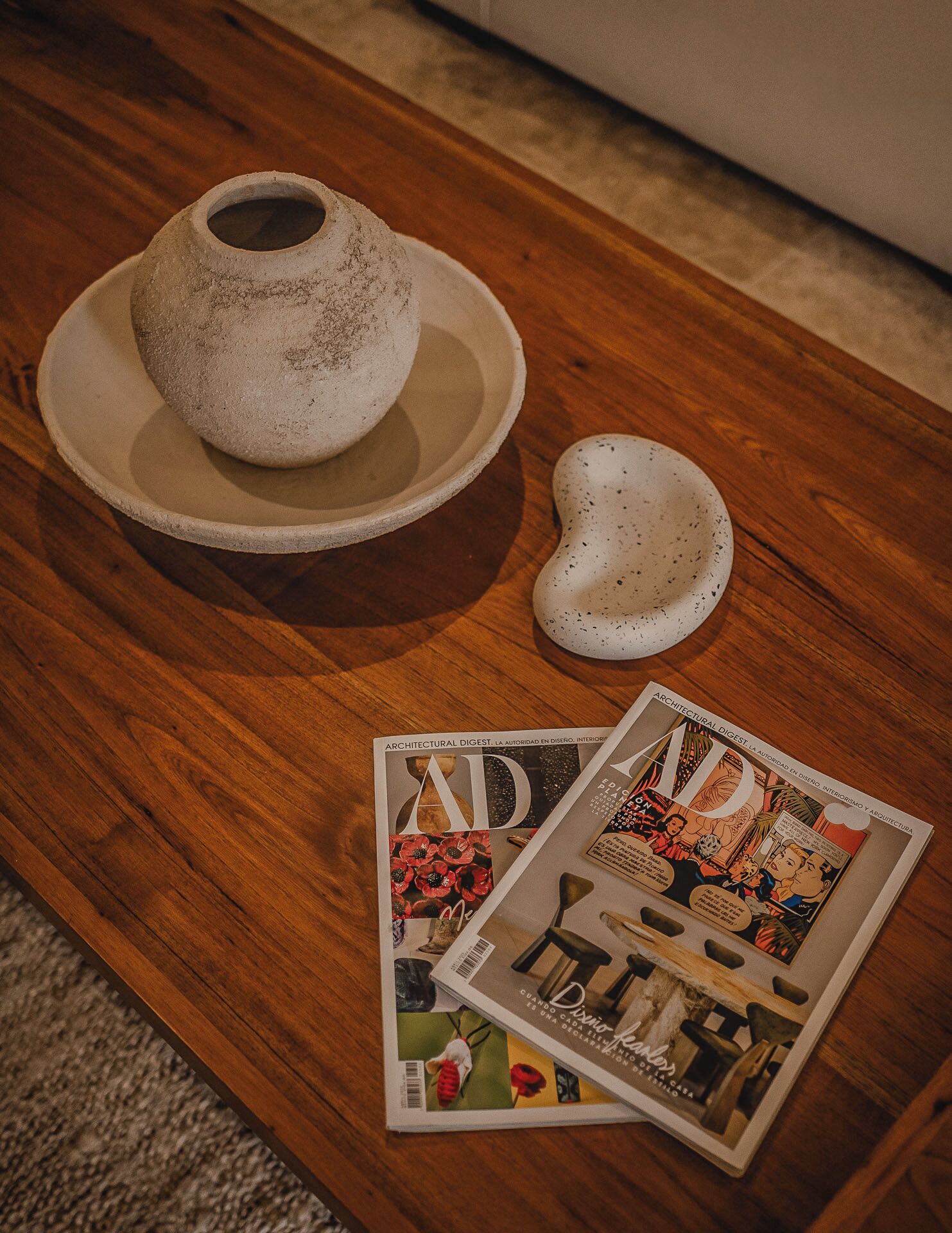 Een tijdschrift met de titel 'AD' op een houten tafel.