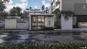 A modern building with a gated entrance, a pool, and a clear sky.