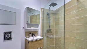 A modern bathroom with a glass shower enclosure, a wooden vanity, and a mirror above the sink. - Nuit Étoilée - Cocoon in the Heart of Arles - A/C (Arles)