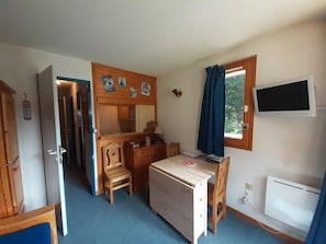 A compact room with a desk, chair, and a television. - 100 meters to the shops, 2nd floor, view of the station/ski lifts, TV, locker for skis (Valfréjus)