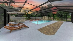 An indoor pool area with lounge chairs, a pool, and a covered patio. - Siesta key paradise in Sarasota (Sarasota)