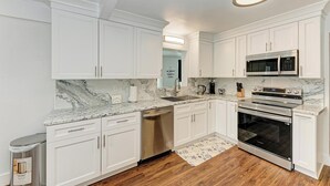 A modern kitchen with white cabinetry, a stainless steel dishwasher, a built-in oven, and a microwave. - Siesta key paradise in Sarasota (Sarasota)