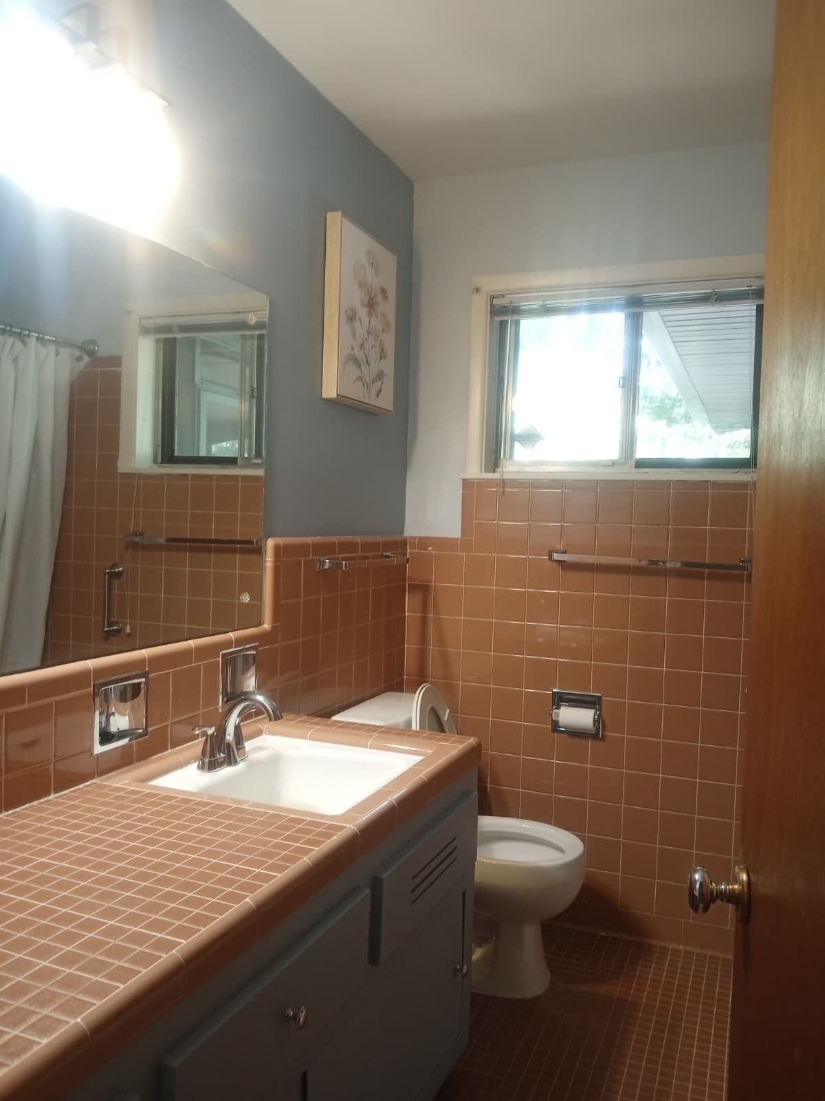A bathroom with a sink, mirror, and toilet.