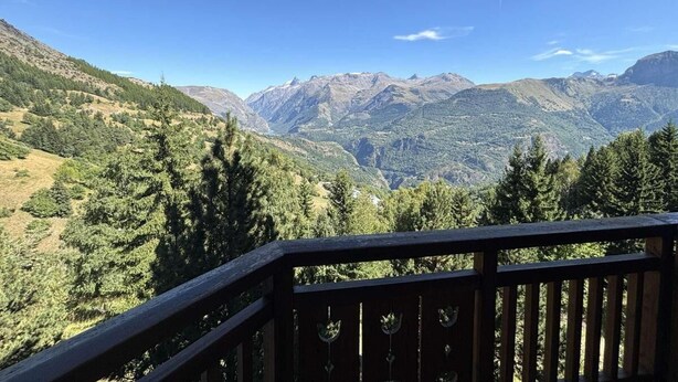 A balcony with a view of a mountainous landscape.