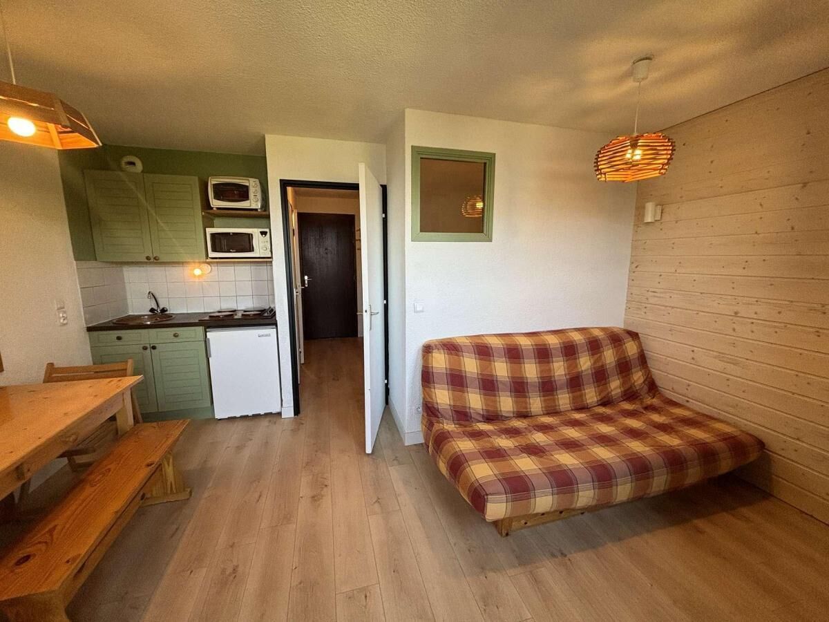 A compact living space with a kitchenette, a dining area, and a sofa.
