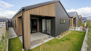 Een modern huis met een houten gevel en een grijs dak.