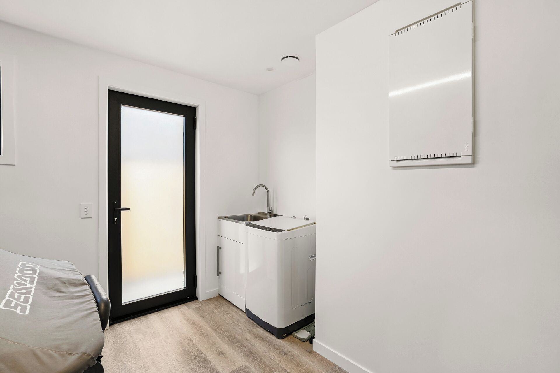 A small, modern kitchen with a built-in sink and a compact refrigerator.